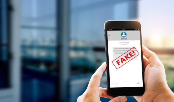 Person holding phone displaying 'FAKE!' on message app